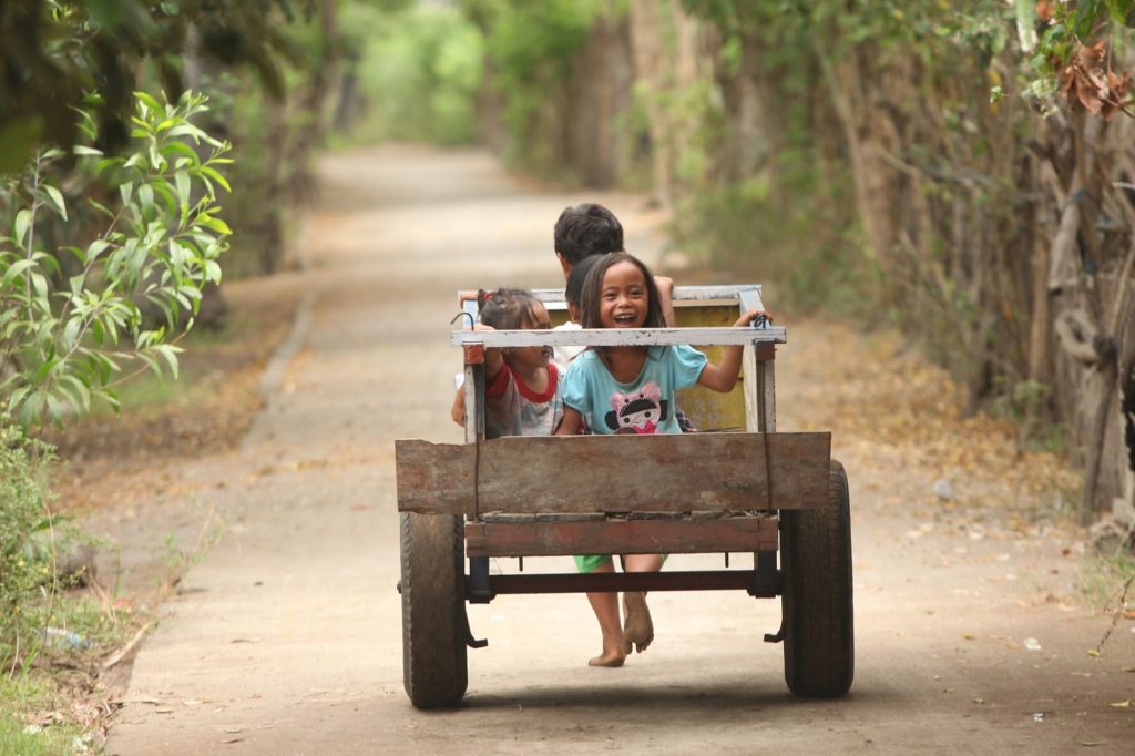 Kinderen rijden op wagen op eiland Gili Meno