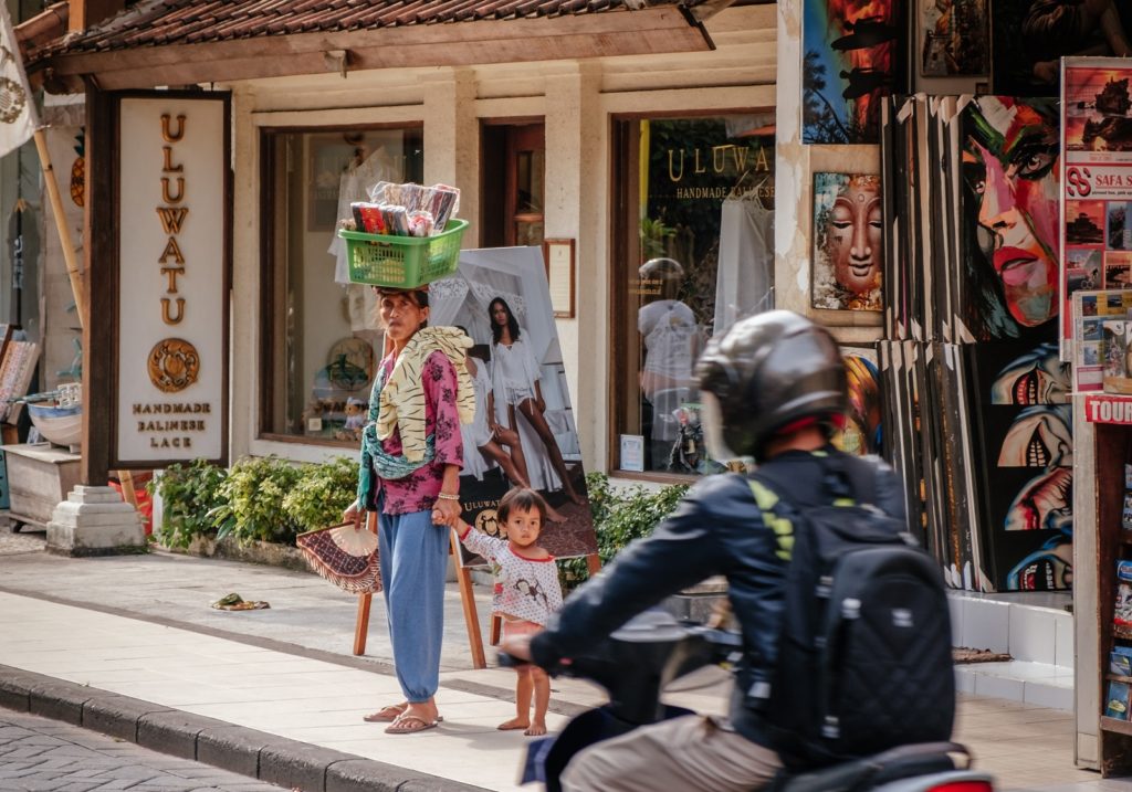 Locals wandelen in de straten van de stad Kuta tijdens backpacken in Bali